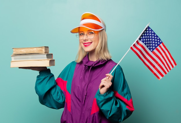 Mulher loira de estilo nos anos 90 esporte terno com livros e bandeira dos EUA