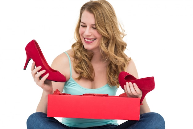 Mulher loira descobrindo sapatos em uma caixa de presente