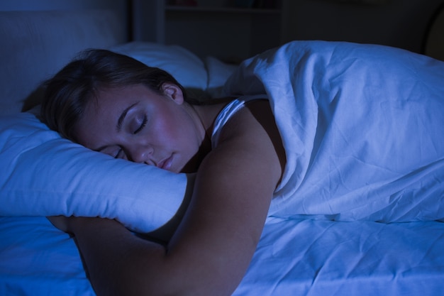 Mulher loira dormindo à noite