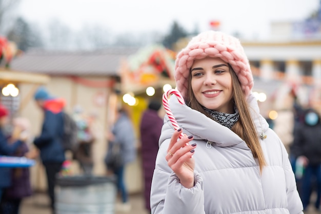 Mulher loira e bonita com doces em uma feira de Natal. Espaço para texto