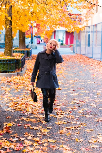 Mulher loira elegante andando explorando a cidade