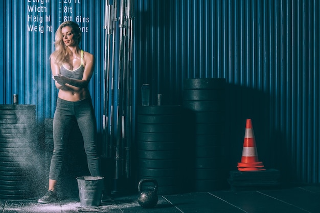 Mulher loira em forma se preparando para treinar na academia