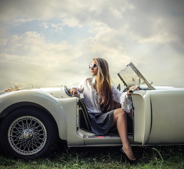 Foto mulher loira em um carro esporte