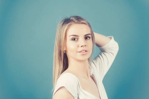 Mulher loira está sorrindo docemente Retrato de menina perfeita em vestido branco