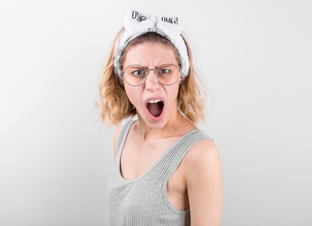 Foto mulher loira feliz surpresa em short branco se alegra e olhando para a câmera sobre o branco