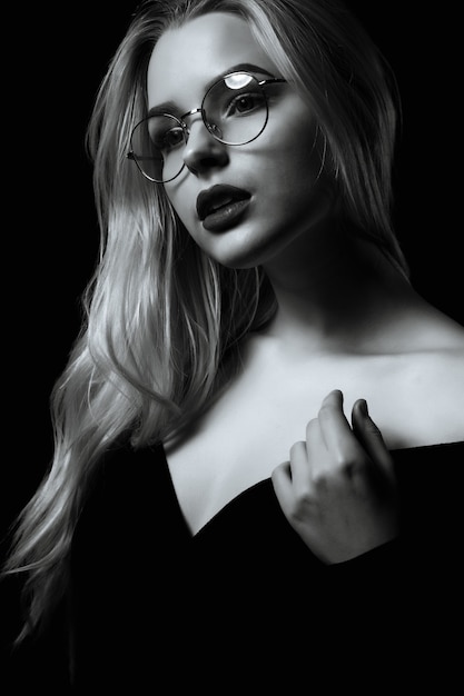 Mulher loira glamour usa óculos posando na sombra. Cor preto e branco