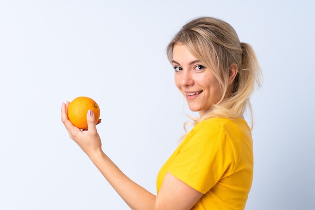 Mulher loira isolada segurando uma laranja