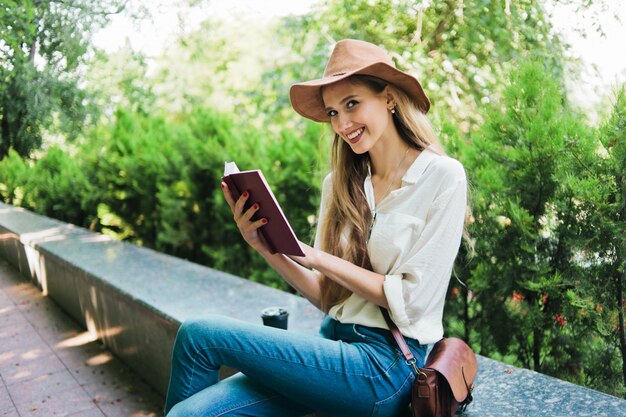 Mulher loira lendo um livro ao ar livre