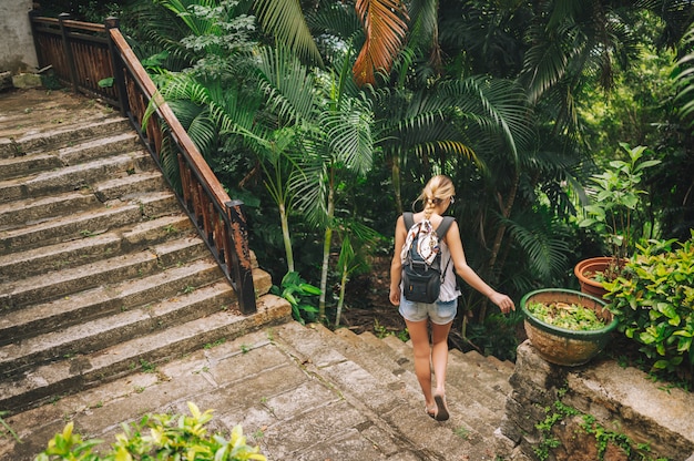 Mulher loira mochileiro viajante andando e descobrindo o parque tropical da selva, natureza de aventura de viagem na China, destino belo turista Ásia, conceito de viagem de férias de férias de verão