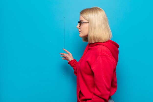 Mulher loira na vista de perfil olhando para copiar o espaço à frente, pensando, imaginando ou sonhando acordada