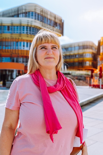 mulher loira olha para o retrato de lado no fundo da arquitetura com luz solar