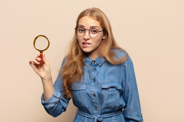 Mulher loira parecendo perplexa e confusa, mordendo o lábio com um gesto nervoso, sem saber a resposta para o problema