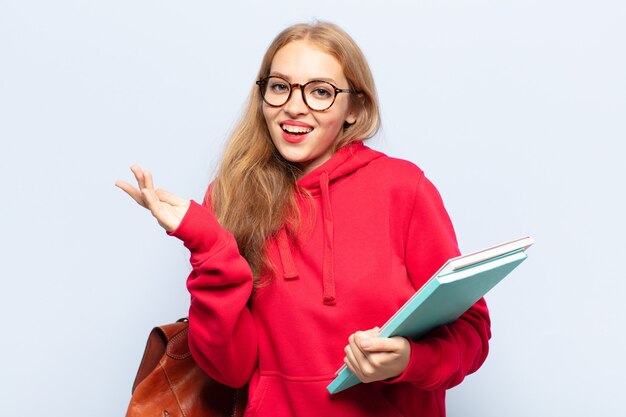 Mulher loira se sentindo feliz, surpresa e alegre, sorrindo com atitude positiva, percebendo uma solução ou ideia