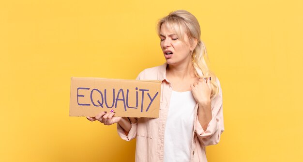 Mulher loira se sentindo frustrada e segurando um cartaz com o texto: Igualdade