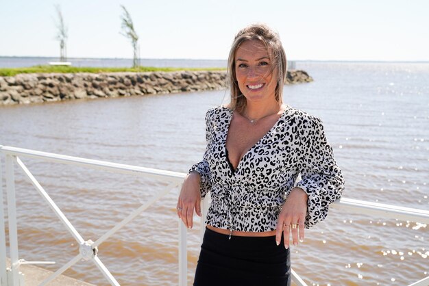 Mulher loira sorrindo retrato de beleza feliz no lado da costa ao ar livre no dia de verão