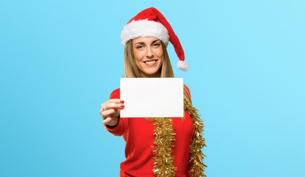 Mulher loira vestida para as férias de Natal, segurando um vazio