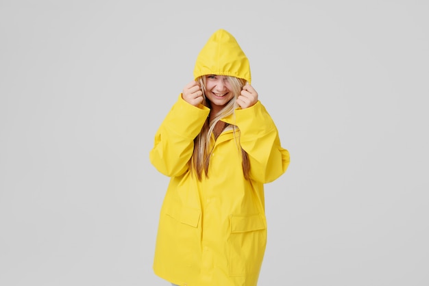 Mulher loira vestindo capa de chuva amarela