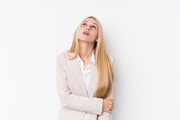 Mulher loura nova do negócio no fundo branco cansado de uma tarefa repetitiva.