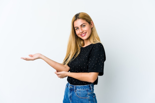 Mulher loura nova isolada no branco que guarda um espaço da cópia em uma palma.