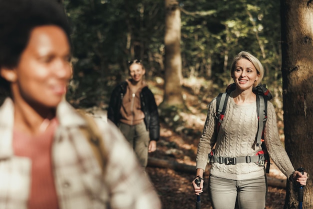 Mulher madura caminhando pelas montanhas com seus amigos.