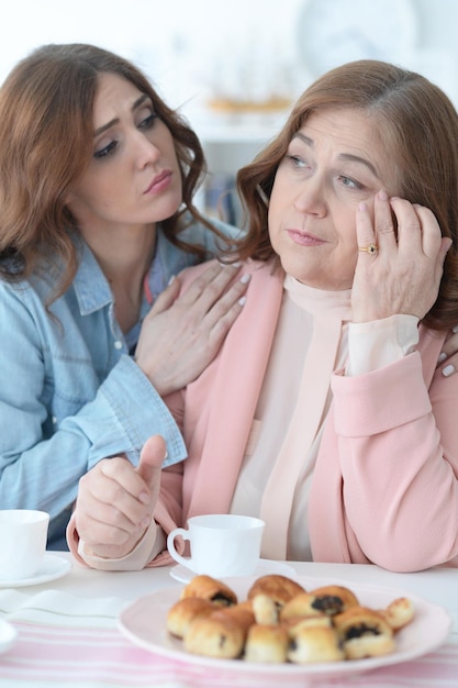 Mulher madura conversando com a filha adulta enquanto bebia chá