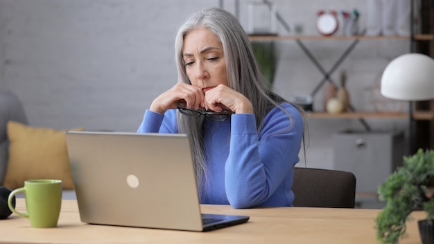 Mulher madura deprimida recebeu más notícias online. Síndrome de burnout, excesso de trabalho, depressão.