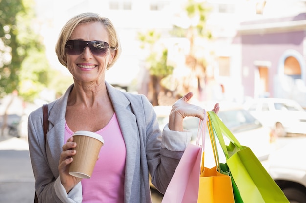 Foto mulher madura feliz caminhando com suas compras compras