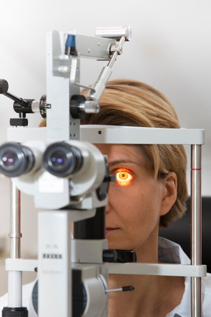 Foto mulher madura olhando através do equipamento de teste ocular