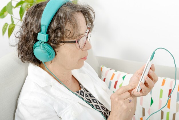 mulher madura, ouvindo música com fones de ouvido