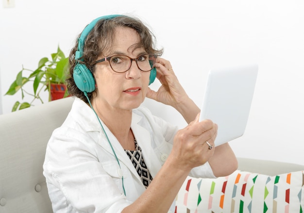 Mulher madura, ouvindo música com fones de ouvido