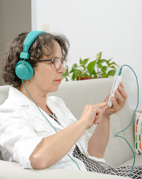 Mulher madura, ouvindo música com fones de ouvido