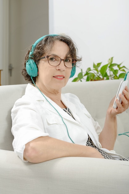 Mulher madura, ouvindo música com fones de ouvido