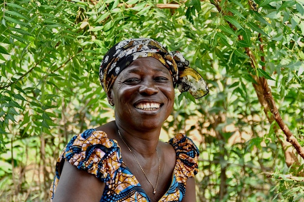Mulher madura sorridente ao ar livre contra a árvore