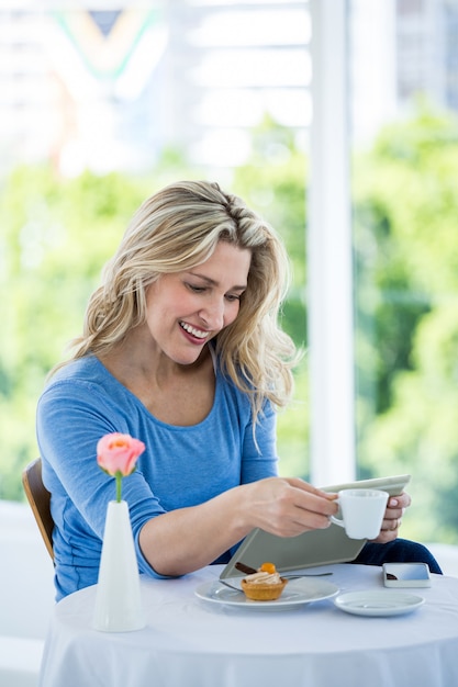 Mulher madura sorridente usando tablet digital