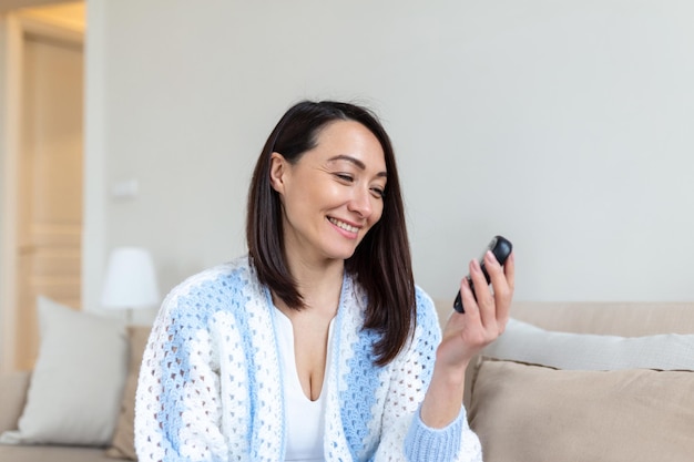 Mulher madura testando para alto nível de açúcar no sangue Mulher segurando o dispositivo para medir o açúcar no sangue Mulher fazendo teste de açúcar no sangue Mulher verificando o nível de açúcar no sangue por glicosímetro e tira de teste em casa