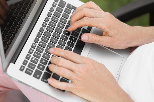 Mulher madura trabalhando com laptop ao ar livre closeup