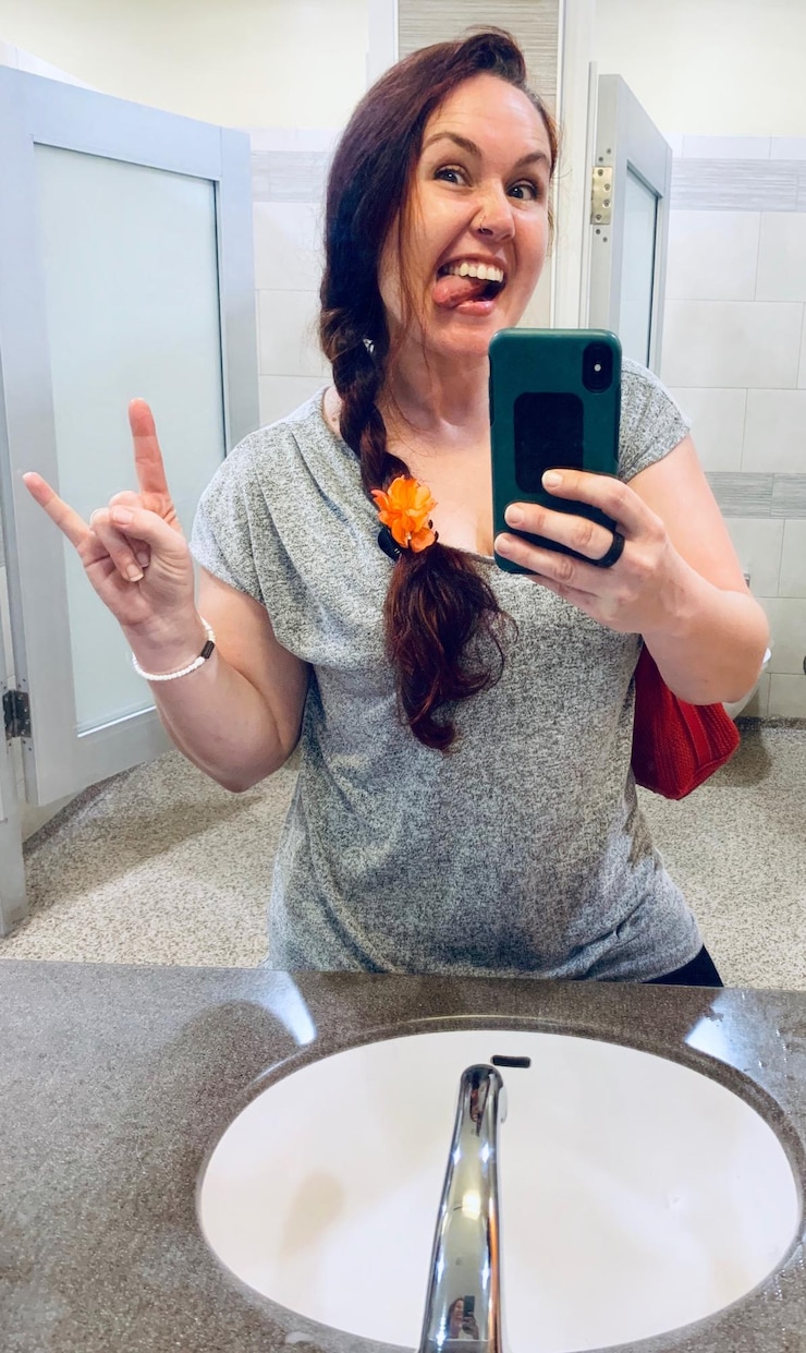 Foto mulher madura usando o telefone enquanto está de pé na casa de banho