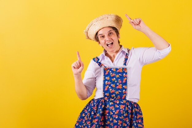 Mulher madura vestida com roupas típicas da Festa Junina Dançando festejando desfrutando