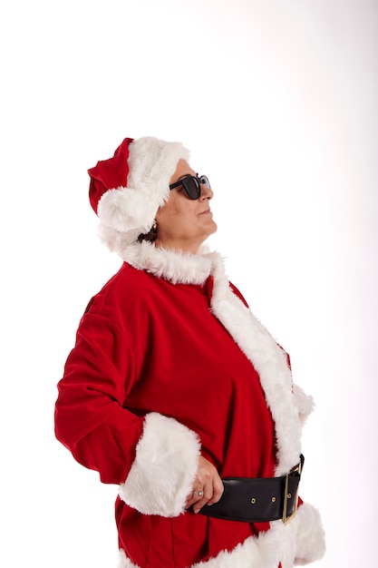 Mulher madura vestida de Papai Noel com óculos escuros em um fundo branco