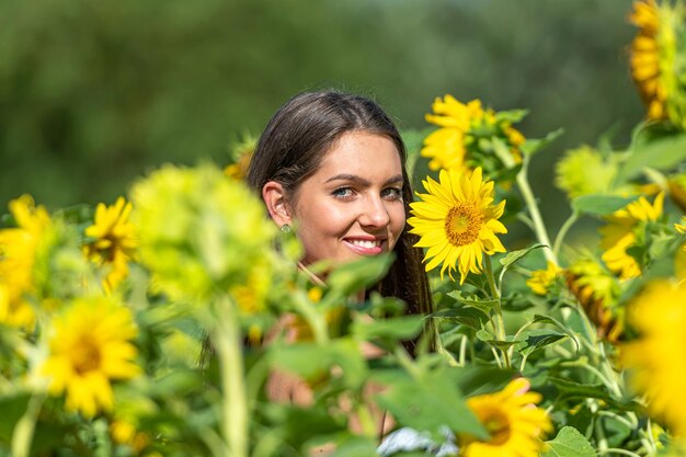 mulher magra sensual com cabelos longos em um campo de girassol em um dia de verão ensolarado