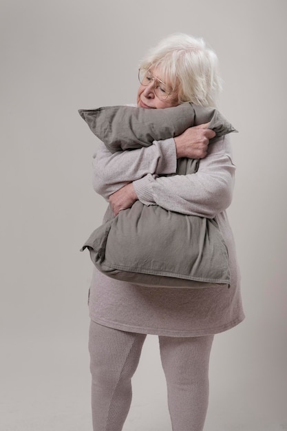 mulher mais velha a abraçar uma almofada