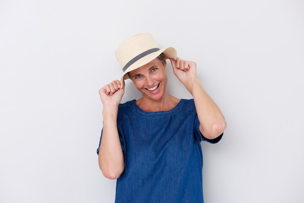 Mulher mais velha feliz rindo com chapéu contra fundo branco