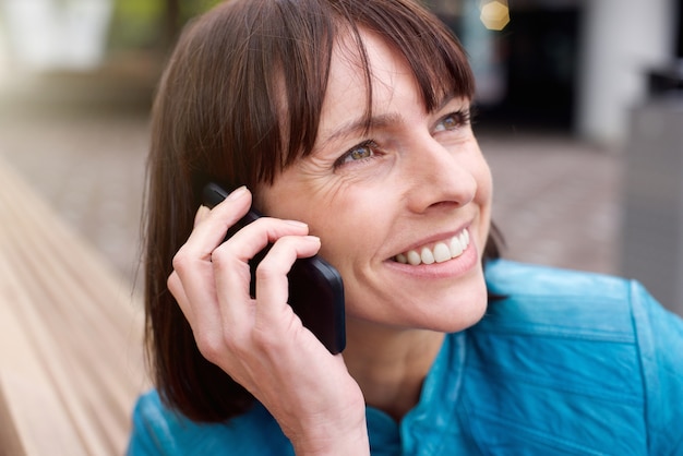 Mulher mais velha, sorrindo, com, telefone móvel, exterior