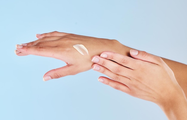 Mulher manicure creme para as mãos e cuidados com a pele beleza estética e cosméticos de bem-estar de luxo e dermatologia no estúdio fundo azul Dedos de loção hidratante closeup e cuidados com o corpo limpo e saudável