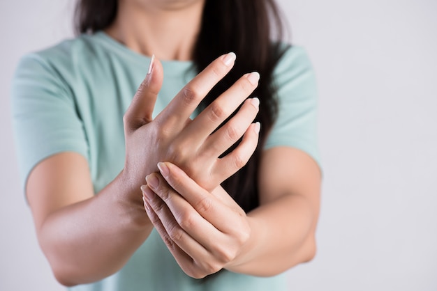 Mulher mantém sua lesão na mão pulso, sentindo dor. Cuidados de saúde e assistência médica.