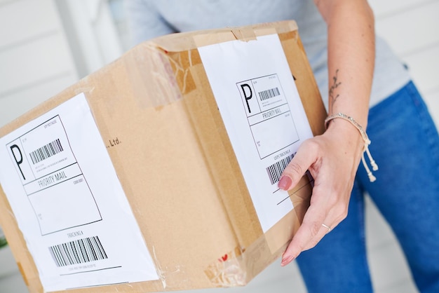 Mulher mãos e caixa para a entrega de encomenda envio e encomenda por casa para o transporte de compra Closeup pacote e importação ou loja on-line e empregado de correio e cadeia de fornecimento para distribuição