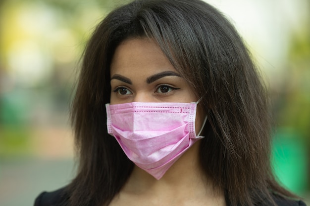 Mulher mascarada - proteção contra o vírus influenza. Mulher afro-americana usando máscara para proteger.