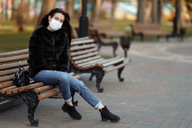 Mulher mascarada sentada em um banco