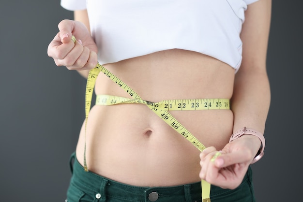 Foto mulher mede a cintura com dieta centimétrica