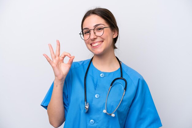 Mulher médica cirurgião segurando ferramentas isoladas em fundo branco mostrando sinal de ok com os dedos